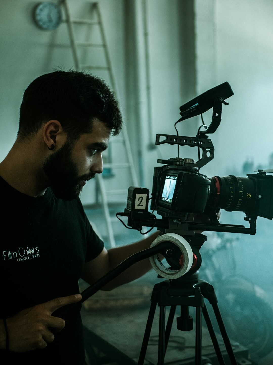 Technician setting up studio camera equipment